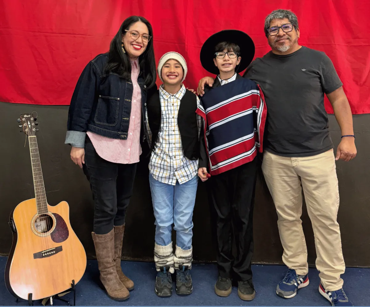 La familia Huanca Bravo con ropa típica chilena en Fiestas Patrias, junto a una guitarra.