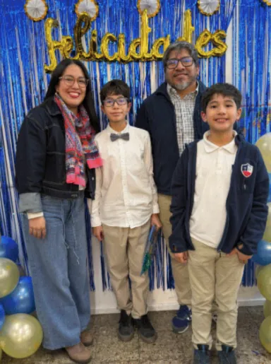 Lucas, de camisa blanca y corbatín, junto a su familia en su ceremonia de graduación.